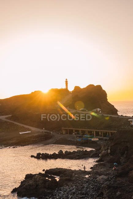 Rocky coast with road and beacon near sea in evening in Tenerife, Canary Islands, Spain — Stock Photo
