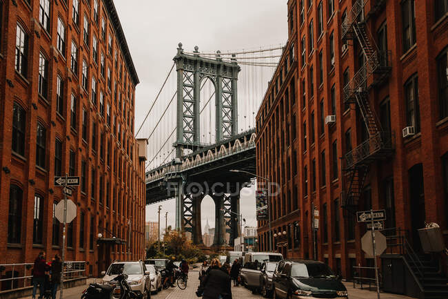 Vista de la antigua calle de la ciudad con edificios de ladrillo rojo y puente entre ellos, Nueva York - foto de stock
