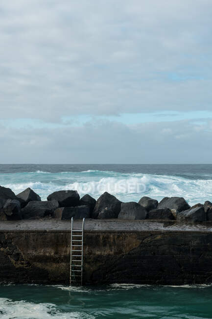 Морська хвиля біля кам'яного пірсу — стокове фото