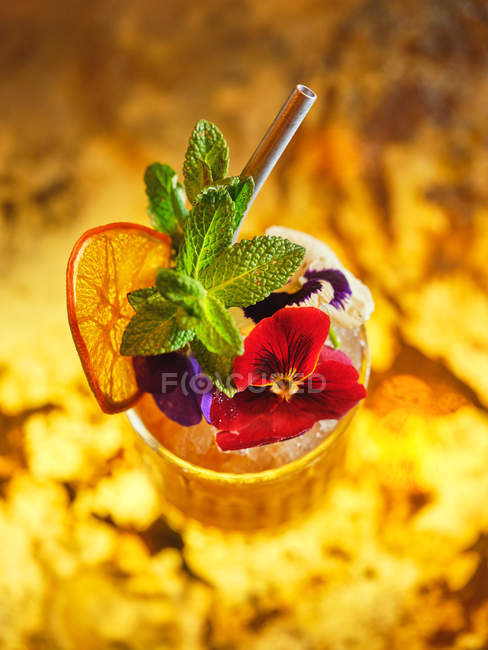 Коктейль украшен фруктами и цветами — стоковое фото