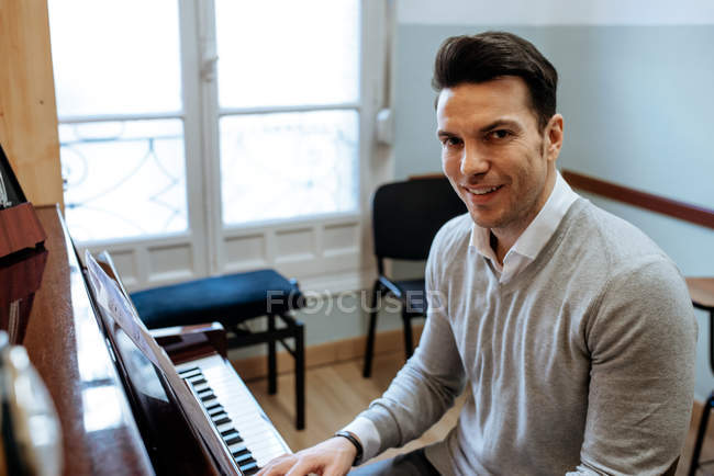Charmant homme jouant du piano pendant la répétition en studio d'enregistrement
. — Photo de stock