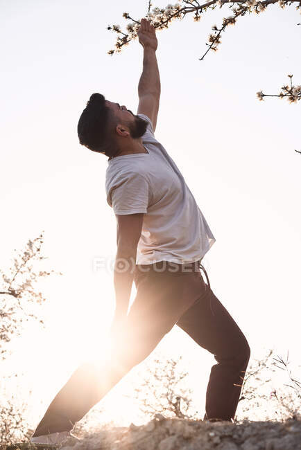 Чоловік робить йогу в весняному саду — стокове фото