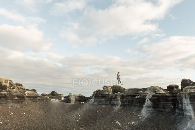 Anonymous female standing of stony terrain — Stock Photo