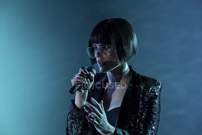 Mulher elegante cantando no palco — Fotografia de Stock