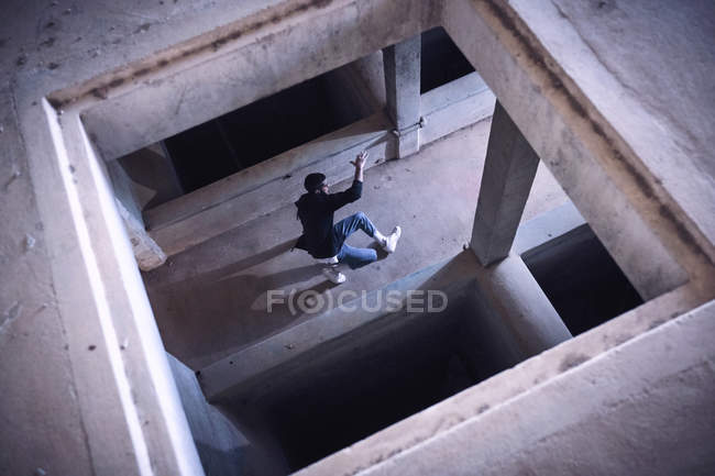 Homme anonyme dansant dans un bâtiment minable, vue grand angle — Photo de stock