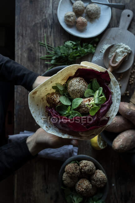 Hands with fresh sweet potato falafel — Stock Photo