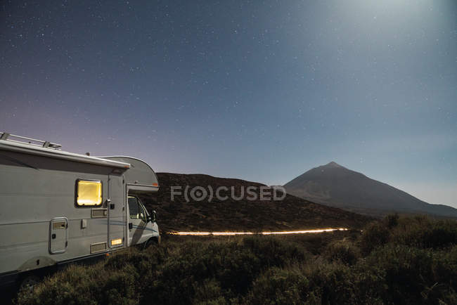 Vista de autocaravana en montaña Teide y cielo con estrellas por la noche en Tenerife, Islas Canarias, España - foto de stock