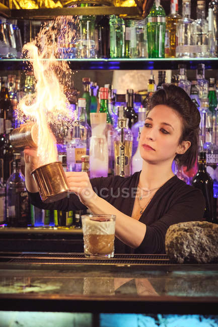 Бармен брызгает коктейлем в баре — стоковое фото