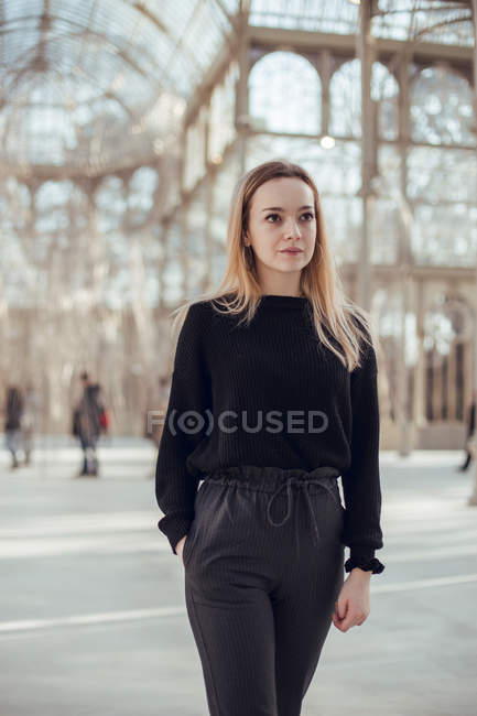 Стильна вдумлива молода жінка, що йде в Кришталевий палац в Мадриді, Іспанія — стокове фото
