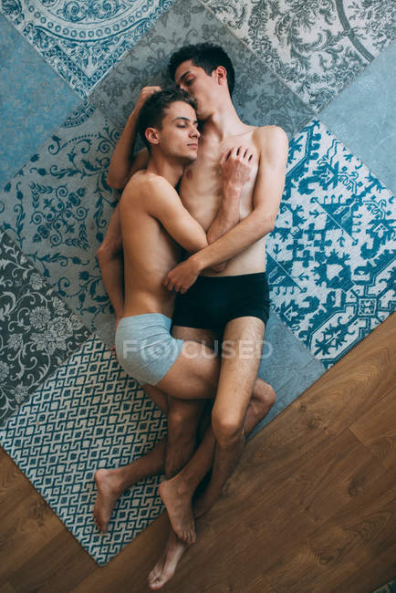Passionate sexual naked gay couple in an intimate moment lying down in a  rug at home — happy, closed eyes - Stock Photo | #255844374