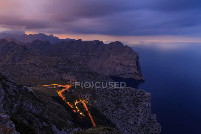 Lunga esposizione di luci di sentiero di notte tra le montagne — Foto stock