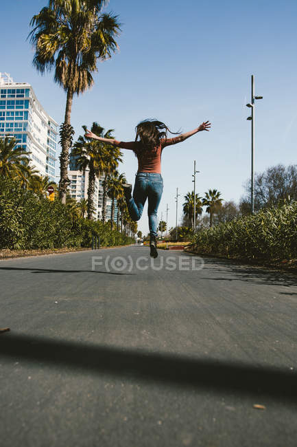 Teen girl walking happily through the streets of the city on a sunny day — Stock Photo