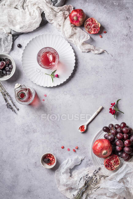 De acima de utensílios diferentes e romã com uvas para fabricação de suco — Fotografia de Stock