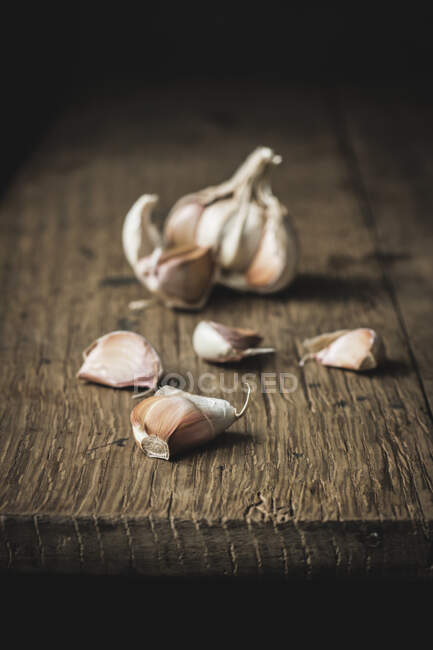 Primo piano aglio non pelato sul tavolo di legno grezzo — Foto stock