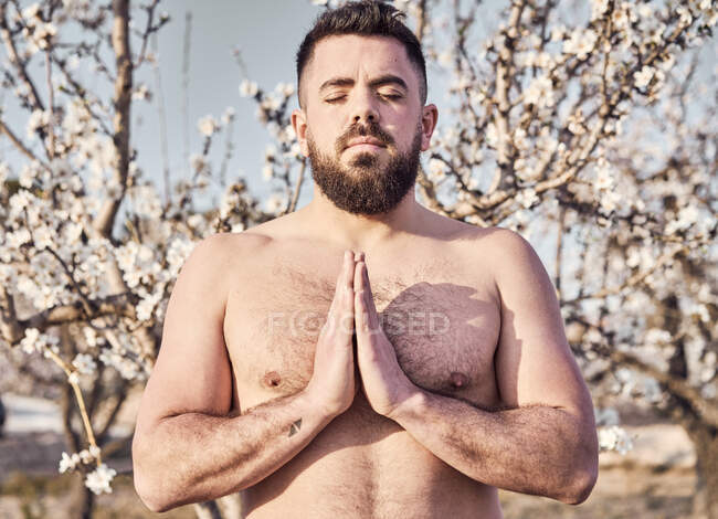 Uomo senza camicia che medita nel giardino primaverile — Foto stock