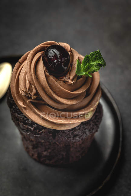 Delicious homemade chocolate cupcake on black plate — Stock Photo