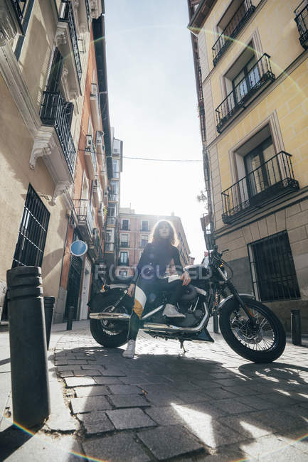 Jeune femme en moto personnalisée — Photo de stock