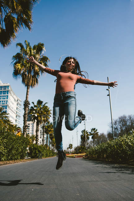 Ragazza adolescente che cammina felicemente per le strade della città in una giornata di sole — Foto stock