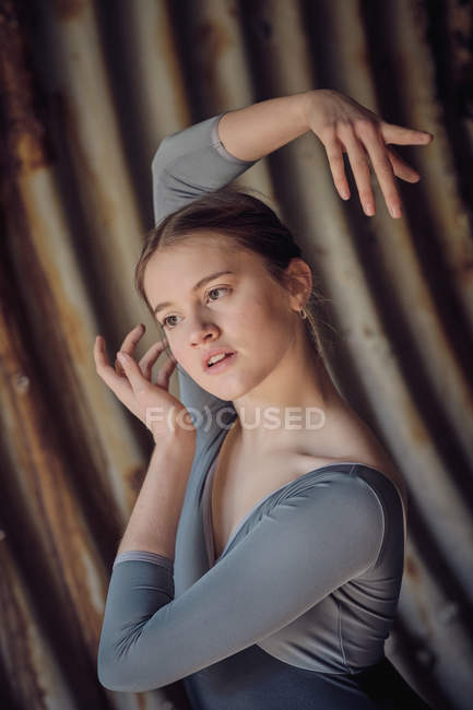 Sensual young female looking away and gesturing with hands while dancing ballet in rusty pipe — Stock Photo