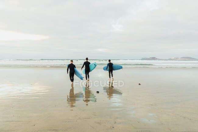 People with surfboard walking near sea — Stock Photo