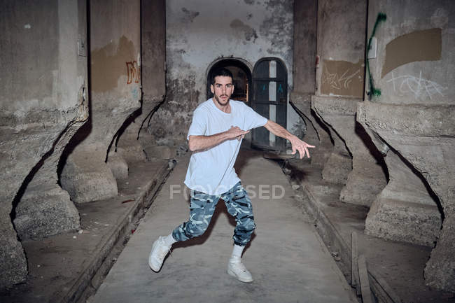 Männlicher B-Boy tanzt im verwitterten Gebäudeinneren — Stockfoto
