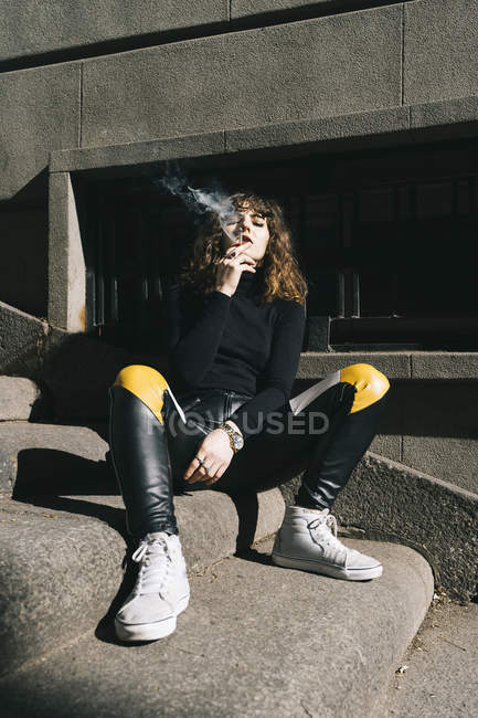 Молода красива жінка курить сигарету на вулиці — стокове фото