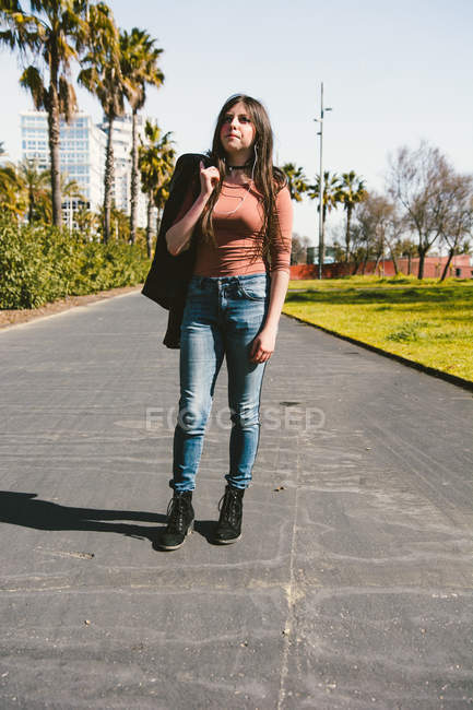 Дівчина-підліток щасливо йде вулицями міста в сонячний день — стокове фото