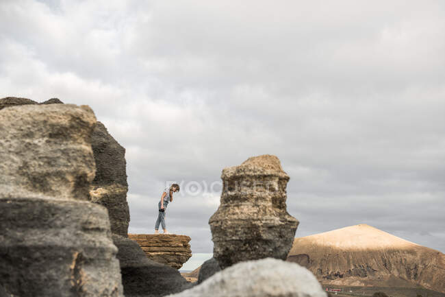 Анонимная женщина фотографирует каменистую местность — стоковое фото