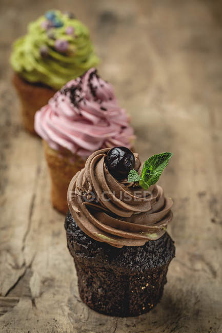 Deliciosos cupcakes caseros sobre fondo rústico de madera - foto de stock
