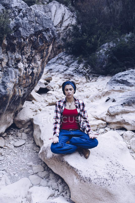 From above attractive smiling woman resting on rock on mountain — Stock Photo