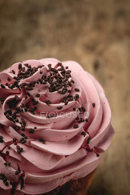 Delicious homemade pink cupcake on rustic wooden background — Stock Photo