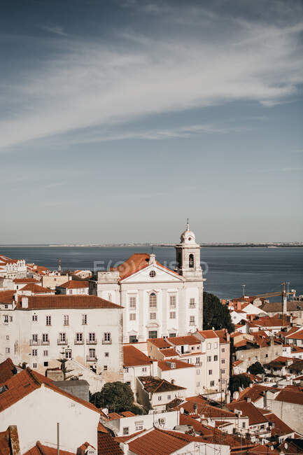 Atemberaubender Drohnenblick auf den blauen Himmel über Ziegeldächern alter Häuser und ruhiger See in Lissabon, Portugal — Stockfoto