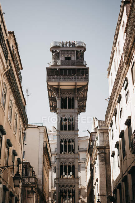 From below majestic ornamental tower located in middle of old street against cloudless blue sky on sunny day in Lisbon, Portugal — Foto stock