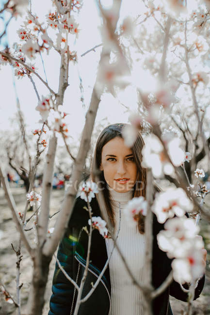 Junge glückliche Frau zwischen Bäumen im Garten — Stockfoto