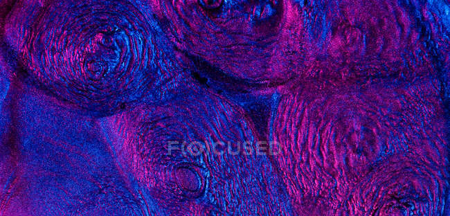 Крупный план феррожидкости, освещенной неоновым светом — стоковое фото