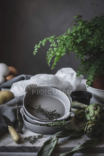 Яйця та різні трави в чашках, покладені на сільський стіл. — Stock Photo