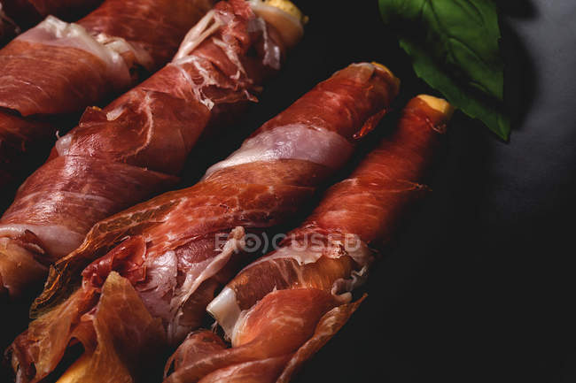 Close-up de gressinis com presunto serrano típico espanhol no fundo escuro — Fotografia de Stock