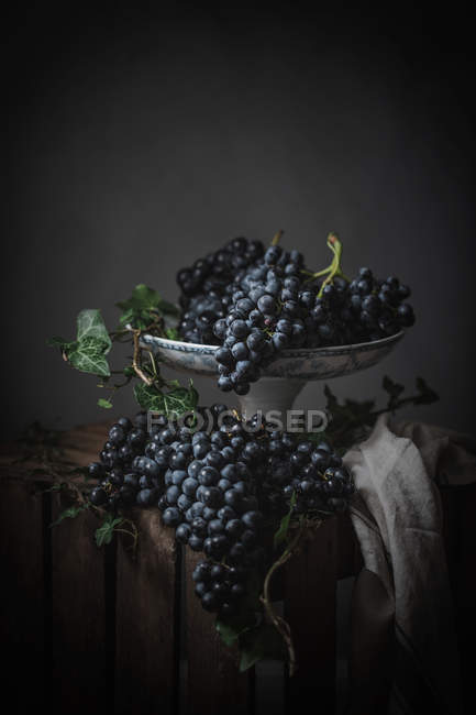 Куча винограда на металлической винтажной пластине на темном фоне — стоковое фото