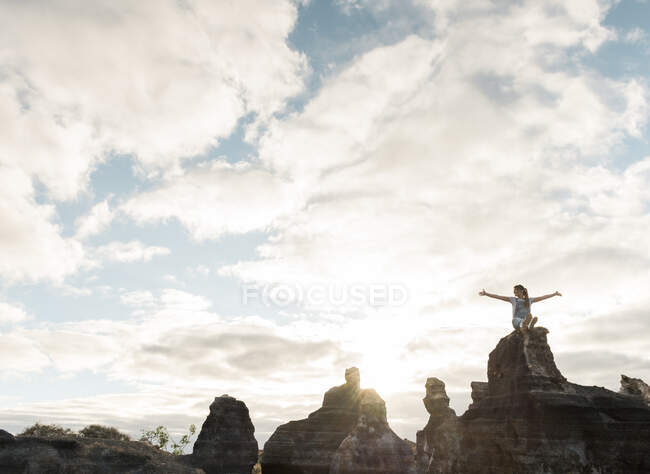 Анонимная женщина сидит на каменистой местности — стоковое фото