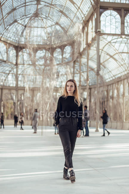 Стильна вдумлива молода жінка, що йде в Кришталевий палац в Мадриді, Іспанія — стокове фото
