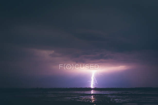 Amazing view of bright lightning shining on dark night sky over calm sea water in Thailand — Stock Photo