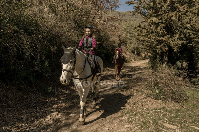 People riding horses in calm creek on sunny day in amazing autumn countryside during lesson — Stock Photo