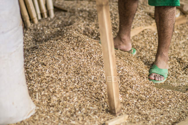 Closeup of male legs near pile of sawdust in workshop — Stock Photo