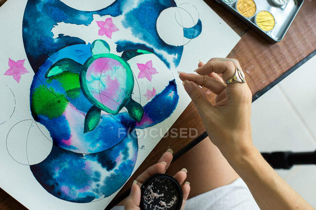 Artista latina pintando con acuarela en su estudio - foto de stock