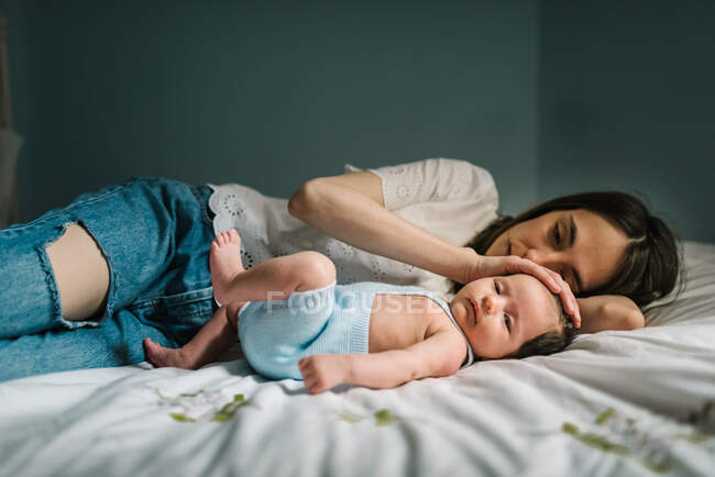 Madre e bambino sdraiati sul letto — Foto stock