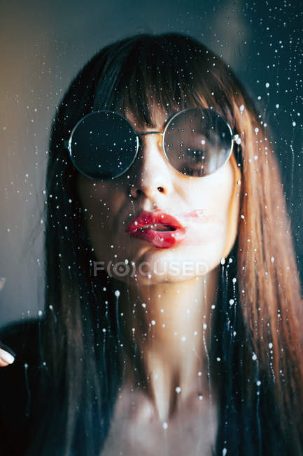 Mulher atraente com lábios vermelhos beijando vidro transparente limpo apaixonadamente — Fotografia de Stock