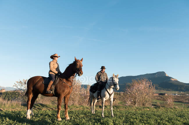 Homme et femme à cheval sur ranch — Photo de stock