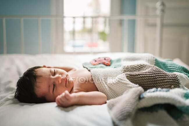 Милый малыш спит на кровати — стоковое фото