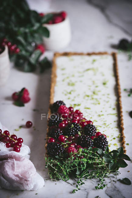 Limettenkuchen mit frischen Beeren auf weißem Marmor — Stockfoto