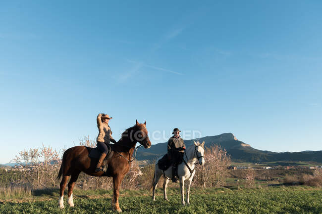 Man and woman riding horses on ranch — Stock Photo
